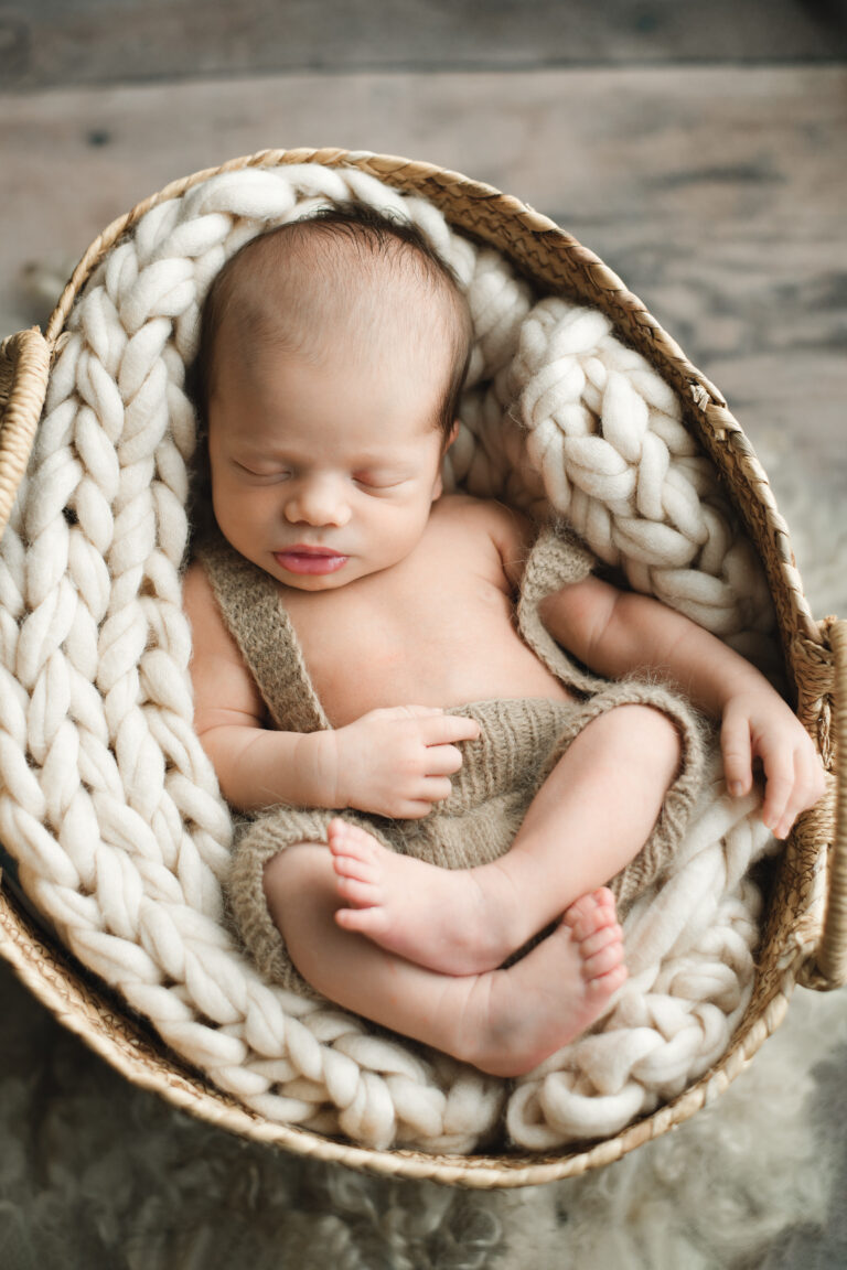 Newborn baby sleeping in basket in Jacksonville studio
